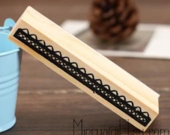 May include: Wooden stamp featuring a black lace design. The stamp is rectangular and has a smooth, unfinished wood surface.