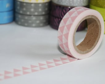 May include: A roll of pink and white washi tape with a triangle pattern. The tape is partially unrolled, revealing the adhesive backing.