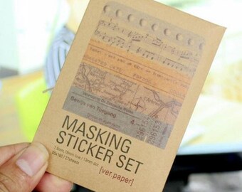 May include: A brown paper packet containing a sticker set with a range of vintage designs. The packet includes 65 sheets of 7.5mm and 15mm lines and 13mm dots. The text on the packet reads "MASKING STICKER SET [ver.paper]"