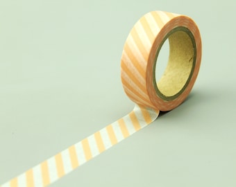 May include: A roll of orange and white striped washi tape with a brown cardboard core. The tape is partially unrolled, showing the striped pattern.