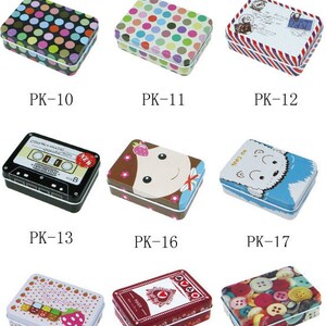 May include: Assortment of small, rectangular tin boxes with various colorful designs. The designs include polka dots, a cassette tape, a cartoon girl, a polar bear, strawberries, playing cards, and buttons.
