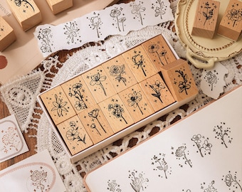 May include: A set of 18 wooden stamps featuring floral designs with a starburst pattern. The stamps are arranged in a grid pattern on a white surface. The stamps are ideal for adding a touch of whimsy to your crafting projects.
