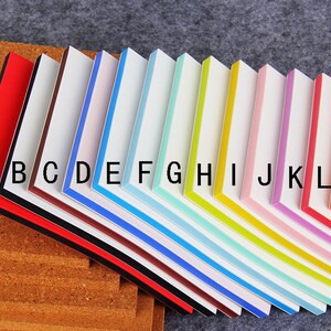 May include: A set of 13 colorful sticky notes with black borders and white centers. The notes are labeled with letters from A to M.