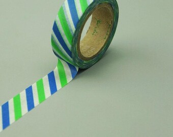 May include: A roll of washi tape with blue, green and white diagonal stripes. The tape is on a grey surface.
