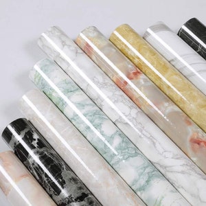 May include: Assortment of marble contact paper rolls in various colors and patterns, including black, white, green, and beige.