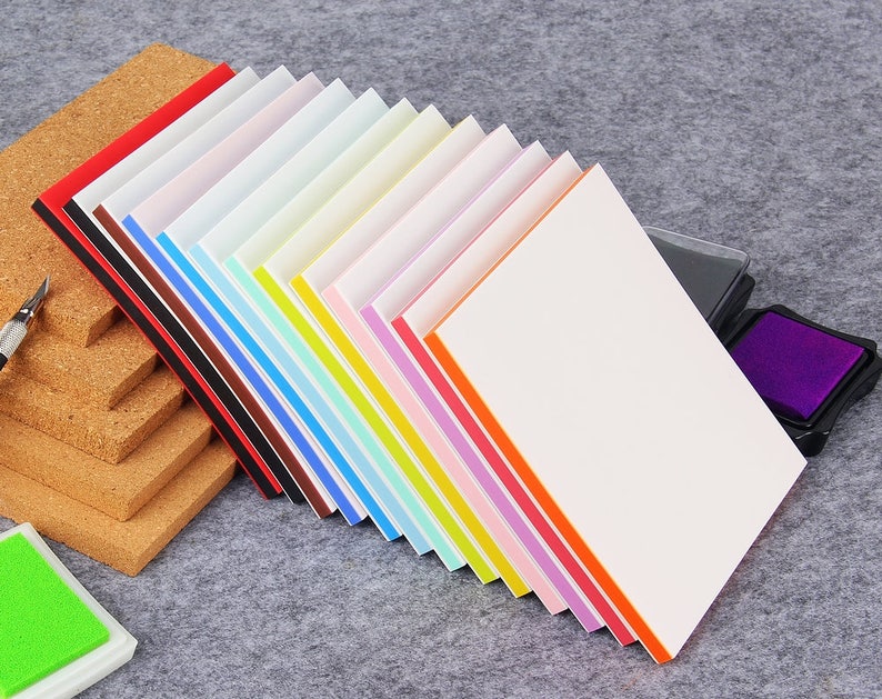 May include: A set of 15 colorful craft stamps with white foam pads. The stamps are arranged in a fan shape with the white foam pads facing out. The stamps are in various colors, including red, orange, yellow, green, blue, purple, and pink.