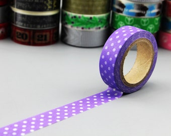 May include: A roll of purple washi tape with white polka dots. The tape is unrolled and the roll is visible.