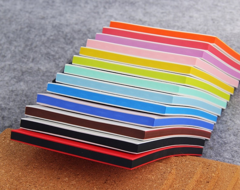 May include: A stack of colorful nail files with black and white stripes. The files are arranged in a rainbow pattern, with red at the bottom and orange at the top.