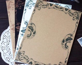May include: Four sheets of decorative stationery paper with a brown background and a green floral border. The paper is blank and ready for writing.