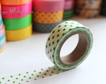 May include: A roll of white washi tape with green polka dots. The tape is partially unrolled, showing the pattern.
