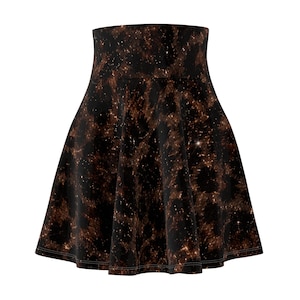 Può includere: Una gonna a ruota a vita alta con un motivo animalier nero e marrone. Il design presenta macchie dorate sparse che ricordano un cielo stellato o glitter, distribuite sul tessuto in una silhouette svasata e circolare.