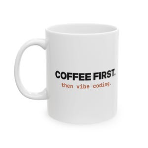 May include: A white ceramic mug with a curved handle featuring the black text COFFEE FIRST. and the orange text then vibe coding. printed on the front. The mug has a smooth, glossy finish and a standard cylindrical shape with a wide opening.