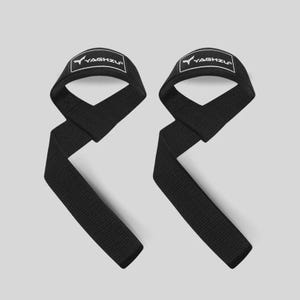 May include: A pair of black weightlifting straps made of durable woven fabric. Each strap features a padded loop for the wrist and a long tail for gripping. The YAGHZU logo is printed in white text inside a rectangular border on each strap.