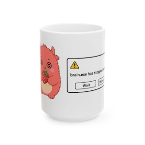 Peut inclure: Un mug en céramique blanche orné d'une illustration de monstre rouge poilu tenant une fraise, à côté d'une fenêtre d'erreur informatique affichant brain.exe has stopped responding avec un triangle d'avertissement jaune et un bouton Wait.