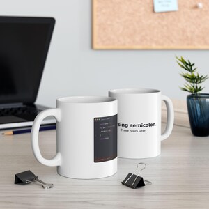 May include: Two white ceramic mugs featuring programming-themed graphics. One mug displays a code editor window with a highlighted error, while the other mug features the black text "missing semicolon. Three hours later." in a sans-serif font.