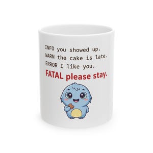 Peut inclure: Un mug en céramique blanche illustré d'une créature bleue de dessin animé tenant un biscuit. Le texte indique : INFO you showed up. WARN the cake is late. ERROR I like you. FATAL please stay. Le mot FATAL est écrit en rouge, le reste en noir.