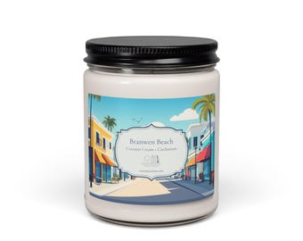 Könnte beinhalten: Ein durchsichtiges Kerzenglas mit schwarzem Deckel und weißem Wachs. Das Etikett zeigt eine farbenfrohe Illustration einer Strandstraßenszene mit Palmen sowie den Text Branwen Beach, Coconut Cream + Cardamom und eine Website-URL.