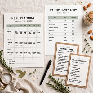 Puede incluir: Una hoja de planificaci&oacute;n de comidas para la semana del 14 al 20 de octubre de 2024, una lista de inventario de despensa y dos tarjetas de recetas para avena nocturna y verduras asadas con quinoa. Un bol&iacute;grafo negro acompa&ntilde;a los documentos.