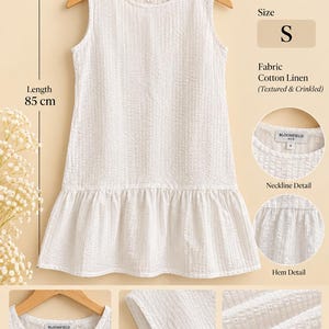 May include: A sleeveless white dress made of textured and crinkled cotton linen fabric. The dress features a round neckline, a drop-waist silhouette with a ruffled hem, and a total length of 85 cm. The garment is labelled with code DV016 and size S.