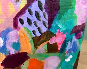 May include: An abstract painting on canvas featuring a vibrant mix of colors including lavender, teal, bright orange, hot pink, and deep purple. The composition includes bold brushstrokes and a section of lavender paint marked with small black dashes.