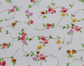 May include: White fabric with a repeating floral pattern. The design features pink roses, purple and yellow flowers, and green leaves on thin, brown stems. The overall effect is a delicate, vintage-inspired print.