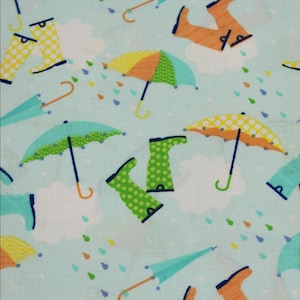 May include: A light blue fabric featuring a repeating pattern of colorful umbrellas, white clouds, and polka-dot rain boots in shades of yellow, green, and orange, interspersed with small blue, green, and orange raindrops throughout the design.