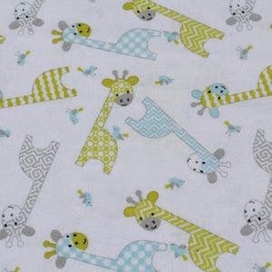 May include: White fabric with a repeating pattern of giraffes and small birds. The giraffes are in shades of yellow, blue, and gray, with various patterns. The birds are small and blue. This fabric is suitable for baby items.