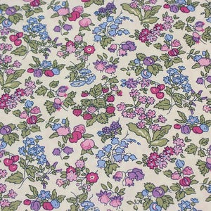 May include: A fabric featuring a dense floral and fruit pattern on a cream background. The design includes small strawberries, cherries, and various clusters of blue, purple, and pink flowers with green leaves distributed across the entire surface.