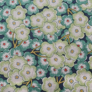 May include: A fabric with a repeating pattern of green and white flowers on a dark blue background.