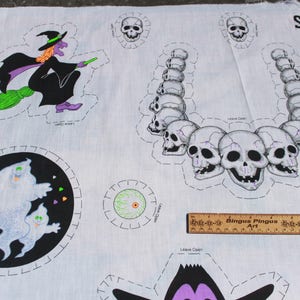 May include: White Halloween-themed fabric with various cut-out designs. Includes a witch on a broom, a skull necklace, ghosts, and a single eyeball. The fabric also has the text "SCARY" and "HALLOWEEN".
