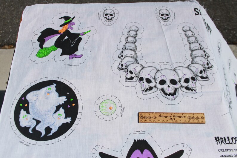 May include: White Halloween-themed fabric with various cut-out designs. Includes a witch on a broom, a skull necklace, ghosts, and a single eyeball. The fabric also has the text "SCARY" and "HALLOWEEN".