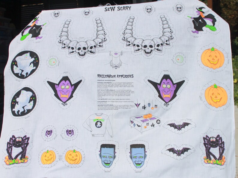 May include: White Halloween-themed fabric featuring various appliqu&eacute;s. Designs include skulls, vampires, pumpkins, ghosts, spiders, bats, and Frankenstein's monster. Text reads "SEW SCARY" and "HALLOWEEN APPLIQUES".