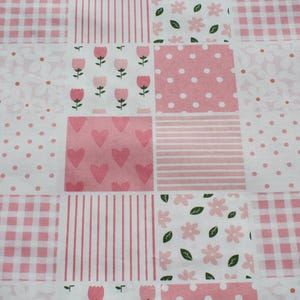 May include: A patchwork fabric design featuring squares with various patterns in pink and white. The patterns include polka dots, stripes, gingham, hearts, flowers, and tulips. The fabric is likely used for quilting or crafting projects.
