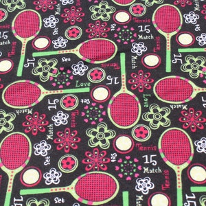 May include: Black fabric with a repeating pattern of pink and green tennis rackets, flowers, and the words "Tennis", "Match", "Set", "Love", and "15".