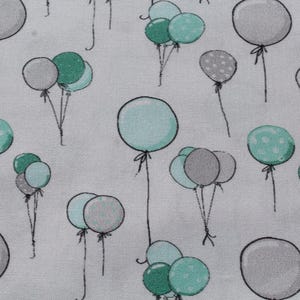 May include: A light gray fabric featuring a repeating pattern of hand-drawn style balloons in shades of mint green, teal, and solid gray. Some balloons are solid, while others feature white polka dot patterns, all connected by thin black strings.