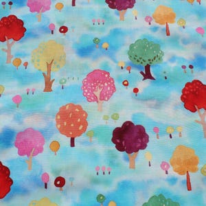 May include: A fabric with a whimsical forest pattern. The design features colorful trees in shades of red, pink, orange, yellow, and green against a light blue, cloudy background. Small, round shapes are scattered throughout.