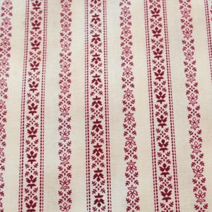 May include: Cream-coloured fabric with vertical stripes of a burgundy floral pattern. The stripes are evenly spaced and feature a repeating design of leaves and dots, creating a classic, decorative textile.