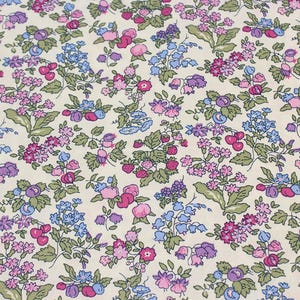 May include: A fabric featuring a dense floral and fruit pattern on a cream background. The design includes small pink, purple, and blue flowers, green leaves, and clusters of red strawberries and dark purple berries scattered across the surface.
