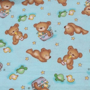 May include: A blue fabric with a repeating pattern of brown teddy bears, yellow ducks, and green turtles. The bears are depicted in various activities, such as taking a bath, playing with a bottle, and lying down. The fabric is perfect for crafting projects, such as quilts, blankets, and pillows.