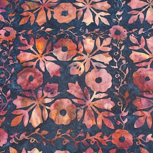 May include: Close-up of a fabric with a floral pattern. The design features large, stylized flowers in shades of orange and pink against a dark blue background. Delicate vines and leaves intertwine among the blooms, creating a textured look.