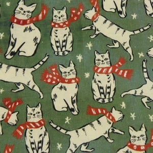 May include: A fabric pattern featuring a repeating illustration of white cats with grey stripes on a dark green background. Each cat is wearing a red scarf with white polka dots or stripes. Small white star-like shapes are scattered throughout.