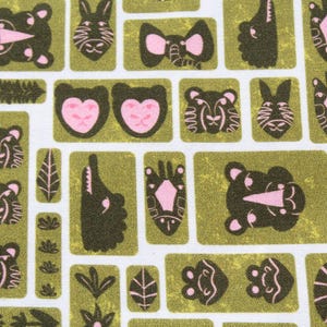 May include: A fabric print featuring a repeating pattern of stylized animal faces and botanical elements in olive green and soft pink on a white background. The design includes elephants, tigers, zebras, and crocodiles arranged in rectangular blocks.