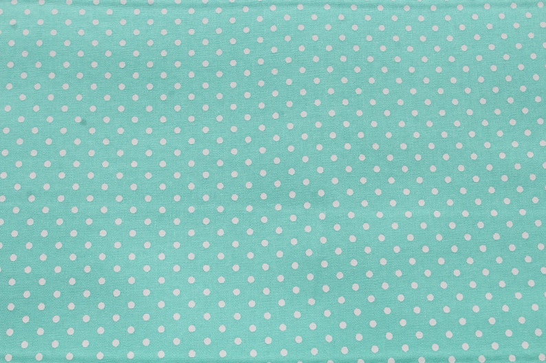 May include: A turquoise fabric with a white polka dot pattern.