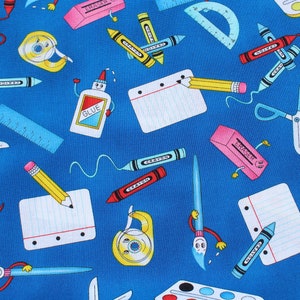 May include: A blue fabric with a repeating pattern of school supplies, including crayons, pencils, scissors, rulers, glue, erasers, and a paint palette. The supplies are all cartoon-like and have happy faces.