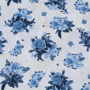 May include: White fabric with a repeating pattern of blue floral bouquets and scattered butterfly shapes. The flowers have detailed petals and dark blue leaves, creating a classic, elegant design.