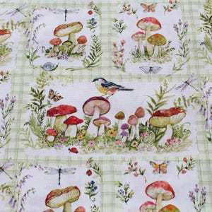 May include: A fabric featuring a repeating pattern of mushrooms, butterflies, and a bird. The design includes red-capped mushrooms, dragonflies, and floral elements on a light green checked background. The style evokes a woodland theme.