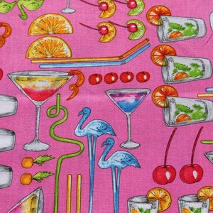 K&ouml;nnte beinhalten: Rosafarbener Stoff mit einem sich wiederholenden Muster aus Cocktails, Flamingos und Zitrusfr&uuml;chten. Das Muster umfasst Martini-Gl&auml;ser, Longdrinkgl&auml;ser und Shaker.