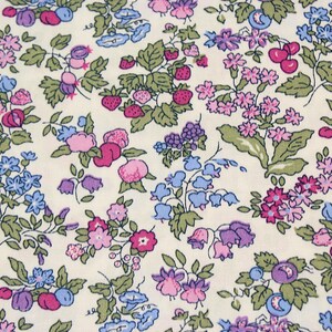 May include: A cream-colored fabric featuring a repeating pattern of small pink strawberries, purple and blue berries, and various small flowers in shades of pink, purple, and blue, all accented with green leaves and stems throughout the design.
