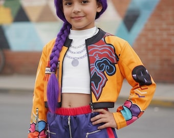 May include: A costume set featuring a bright orange cropped bomber jacket with colorful graphic patterns, a white mock-neck top with a printed silver chain necklace, and purple shorts with red side stripes and silver zipper details.