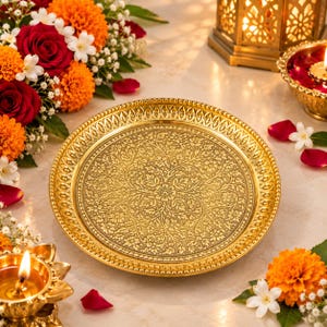 May include: A round, metallic gold-toned decorative plate featuring an intricate, embossed floral pattern across its surface and a textured, beaded border along the outer rim, presented as a singular, polished serving piece.